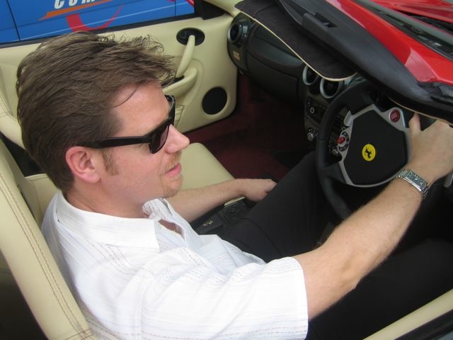At the wheel of a red Ferrari